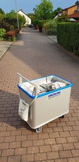 Spring-loaded base trolley for newspaper distribution